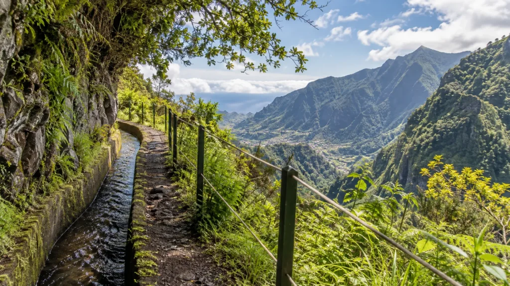 Levada-Wanderweg durch grüne Berglandschaft auf Madeira mit Blick auf steile Täler