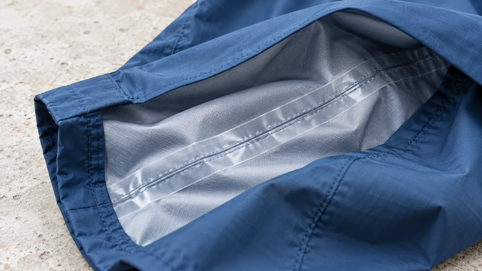Innenseite eines blauen Regenstoffs mit transparentem Band über der Naht